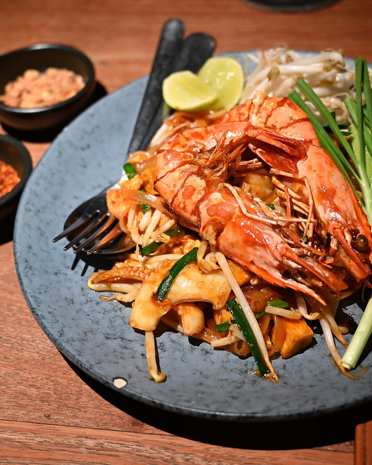 ผัดไทยกุ้งแม่น้ำจัดเสิร์ฟบนจานหินพร้อมเครื่องเคียง